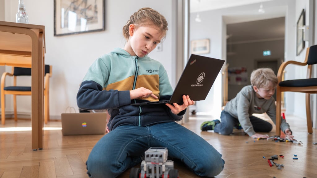 Jonna på ti år og elever på Harreslev-Kobbermølle Danske Skole med computer og robot i Flensborghus lørdag. Det er sjovt at være her, konstaterer hun. Foto: