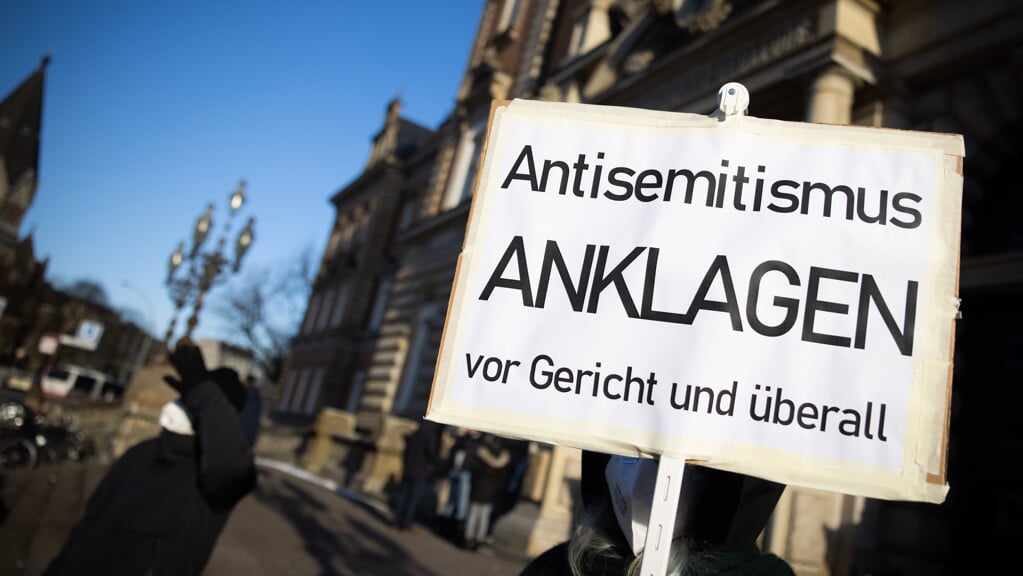 Eine Teilnehmerin einer Kundgebung hält ein Schild mit dem Text »Antisemitismus Anklagen vor Gericht und überall«. Foto: