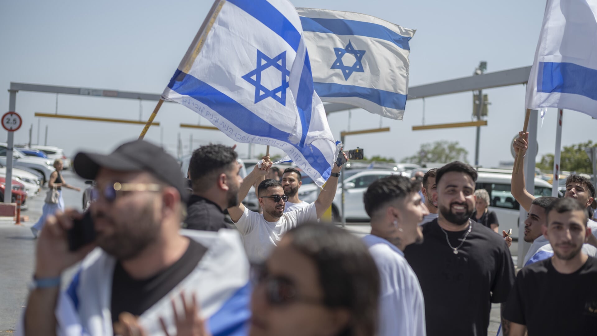 Jublende israelere svingede med flag, da gidslerne lørdag ankom til sygehuset i en forstad til Tel Aviv. Foto