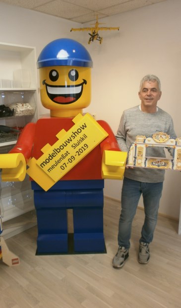 Organisator van de modelshow Johnny Bergakker bij een reuze pop van Lego.