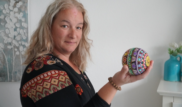 <p>Sylvia met een houten bol, die fraai met Dot painting is bewerkt.</p>