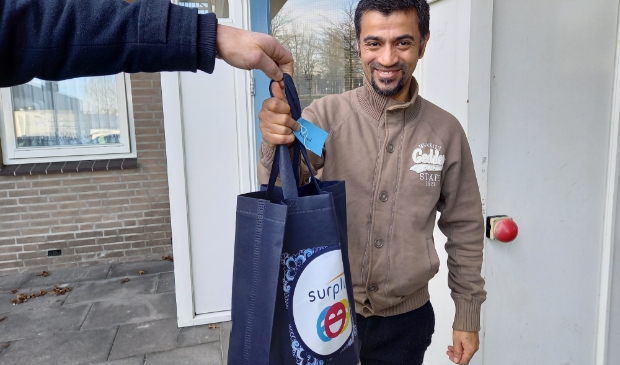 <p>Amjad neemt enthousiast het tasje in ontvangst</p>