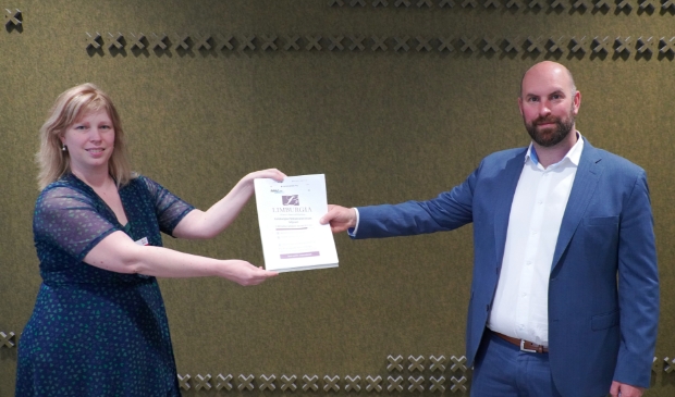 <p>Eveline overhandigt de petitie aan wethouder Boaz Adank</p>