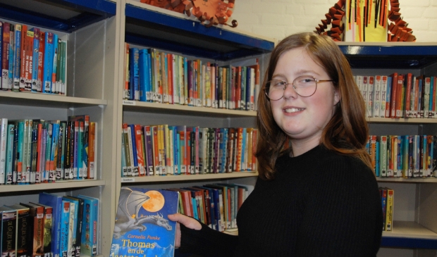 <p>Mara met haar favoriete boek in de bieb van Olympia</p>