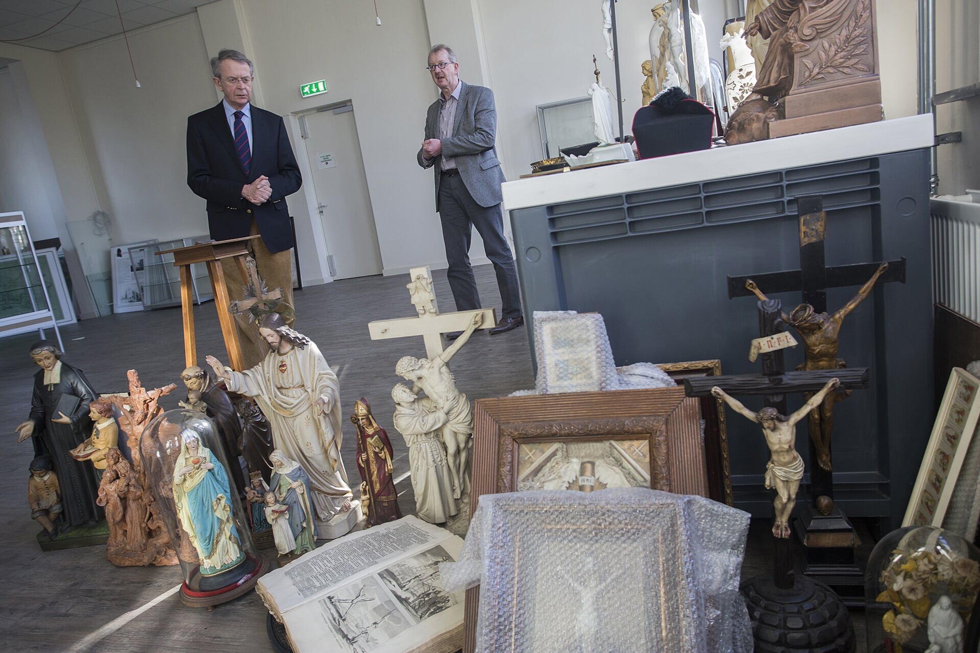 Voorzitter Jan van Homelen en secretaris Willem van Vossen bekijken een deel van Gaudete-collectie tijdens de inrichting van museum MuBo.