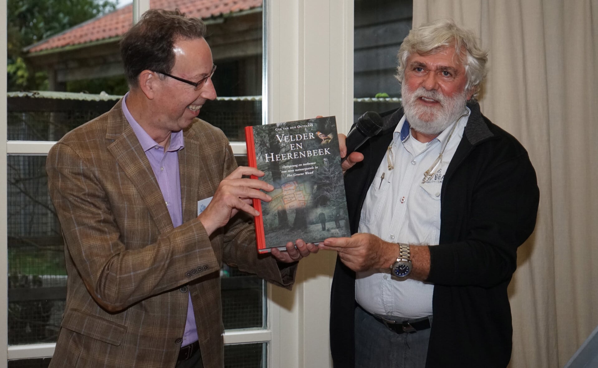 De voorzitters Arnold van den Broek (Kèk Liemt, links) en Ad de Kort (Natuurwerkgroep Liempde) presenteren het eerste exemplaar van het boek over Velder en Heerenbeek. Beide organisaties namen het initiatief voor de lijvige publicatie. (Foto: Albert Stolwijk).