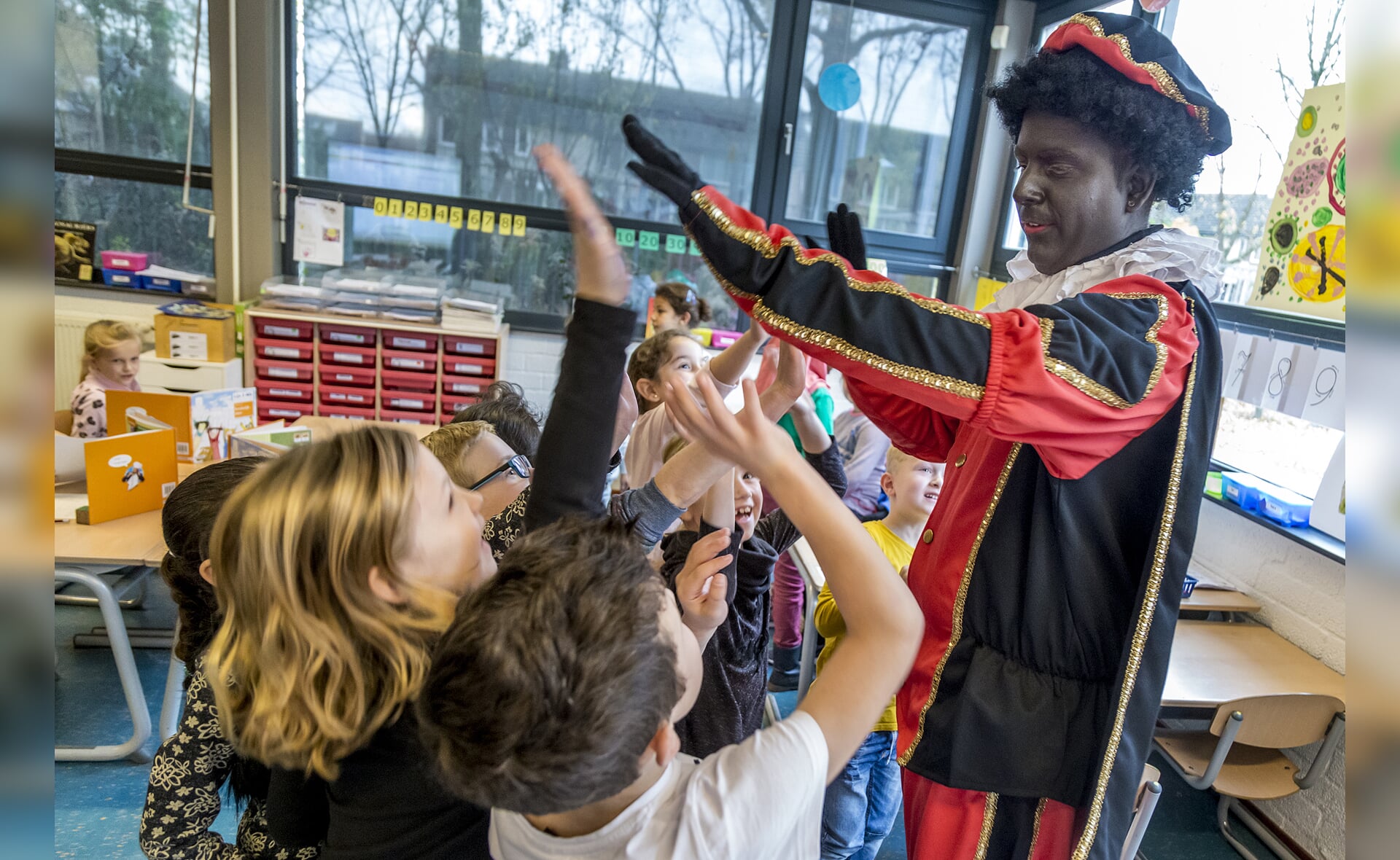 High five! Kinderen van De Spelelier kregen deze week al bezoek van een Piet. Hij kwam de tekeningen en kleurplaten voor Sinterklaas ophalen. (Foto: Peter de Koning).