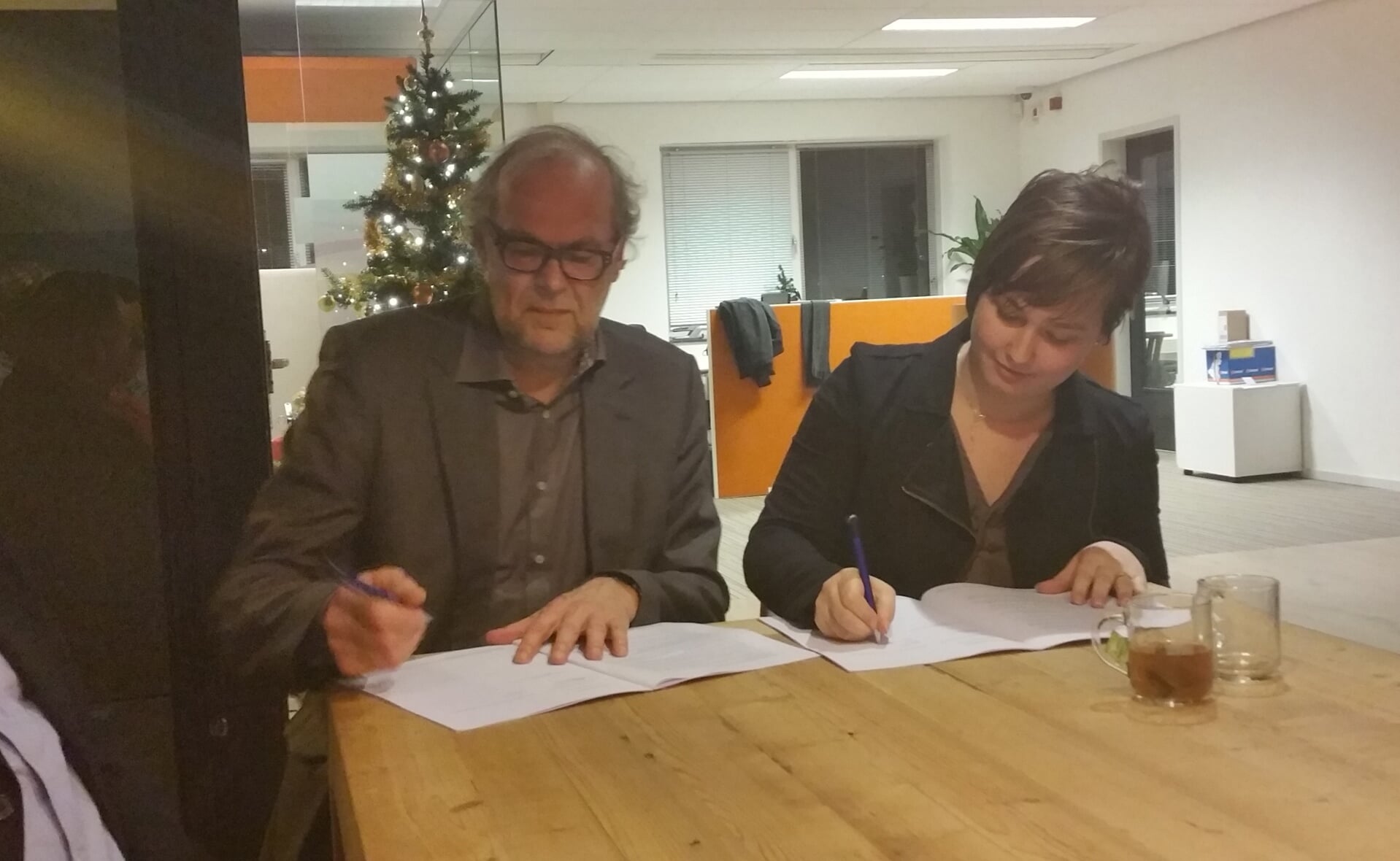 Rob Dekker en Berdine Kamps zetten de handtekening onder een sociaal plan voor de bewoners van 42 sloopwoningen in de Boxtelse wijk Breukelen. (Foto: Marc Cleutjens).