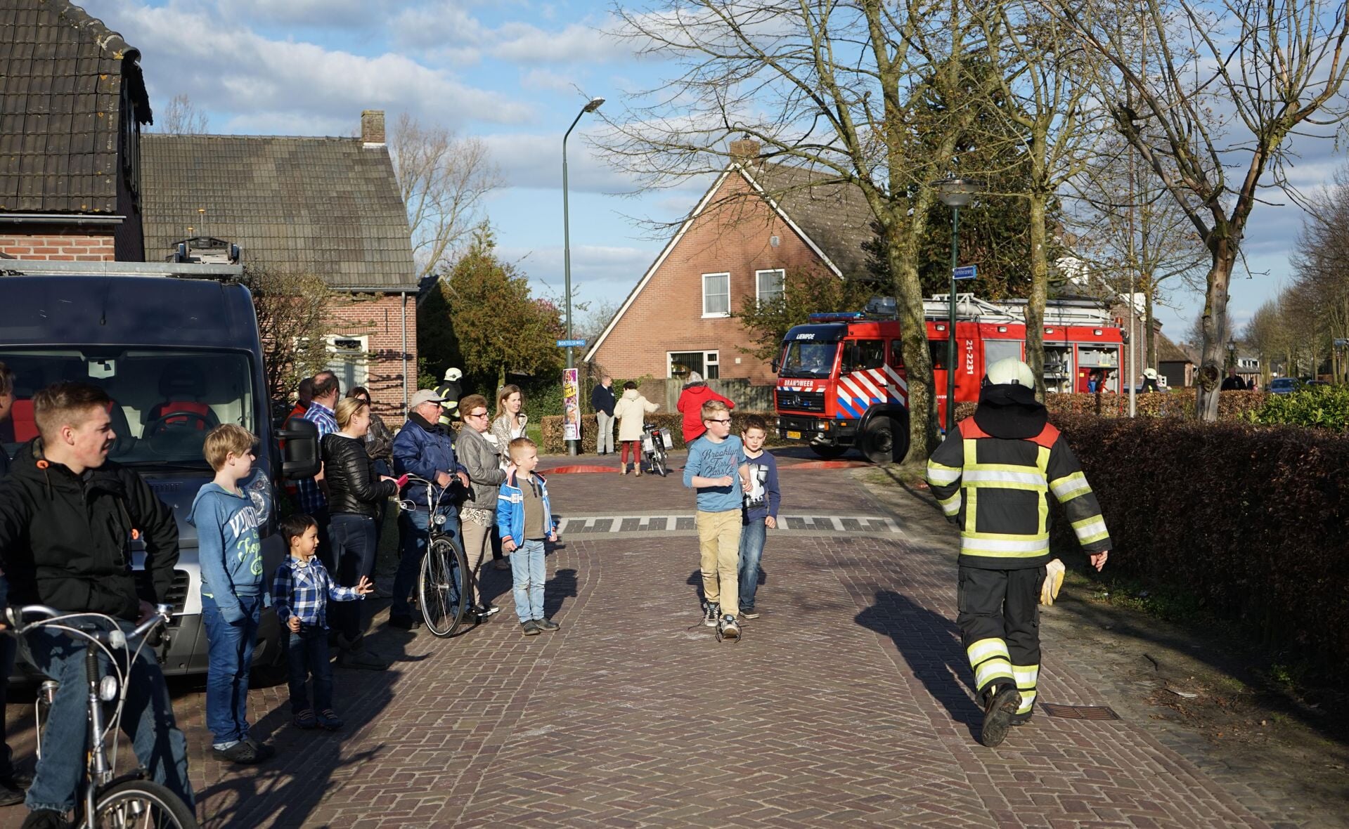 De buitenbrand bij een woning op de grens van de Boxtelseweg en Nieuwstraat in Liempde trok veel bekijks van omstanders. (Foto: Albert Stolwijk).