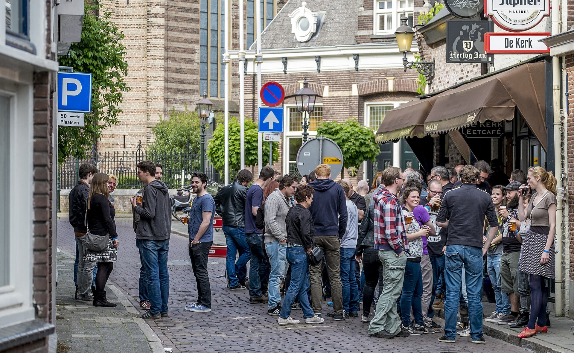 Bezoekers van Church Open Air verzamelen zich voor eetcafé De Kerk. Binnen zijn de optredens, buiten kan gekletst en gedronken worden. (Foto: Peter de Koning).