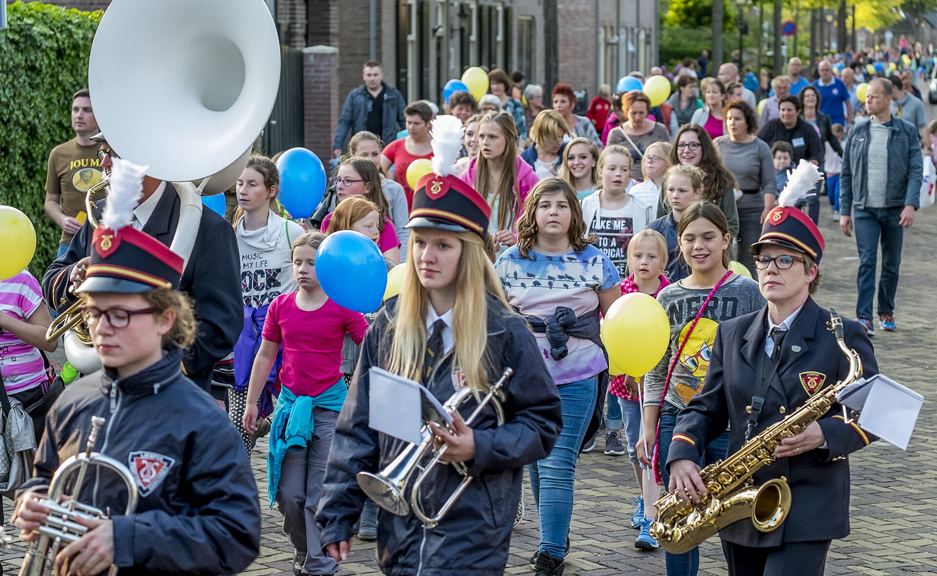 De deelnemers aan de 34e avondwandeldriedaagse in Liempde worden muzikaal onthaald door fanfare Concordia. (Foto: Peter de Koning).