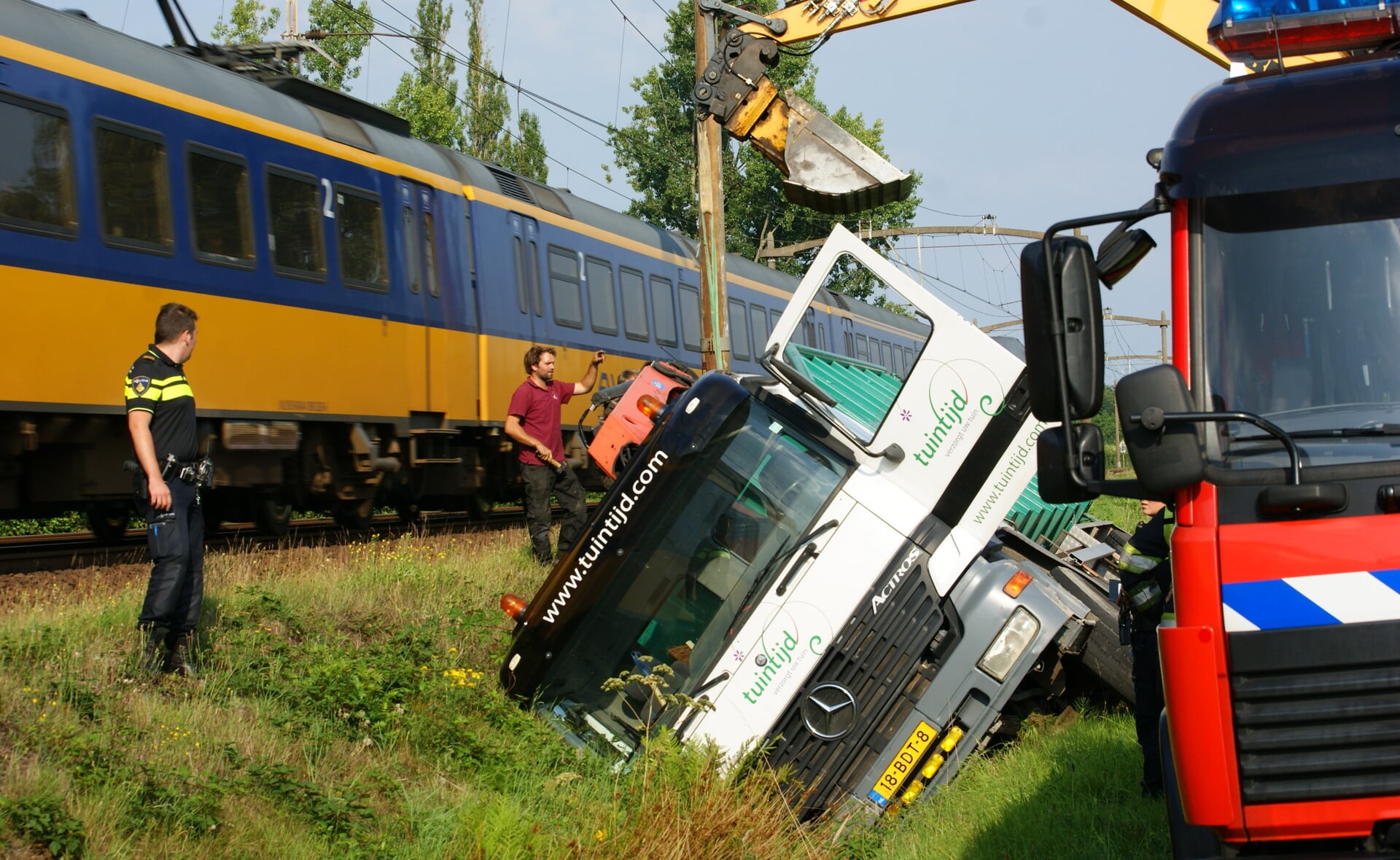 Een trein passeert de plek waar vrijdagmiddag op de Kapelweg een truck in de sloot belandde. De chauffeur bleef ongedeerd. (Foto: Marc Cleutjens).