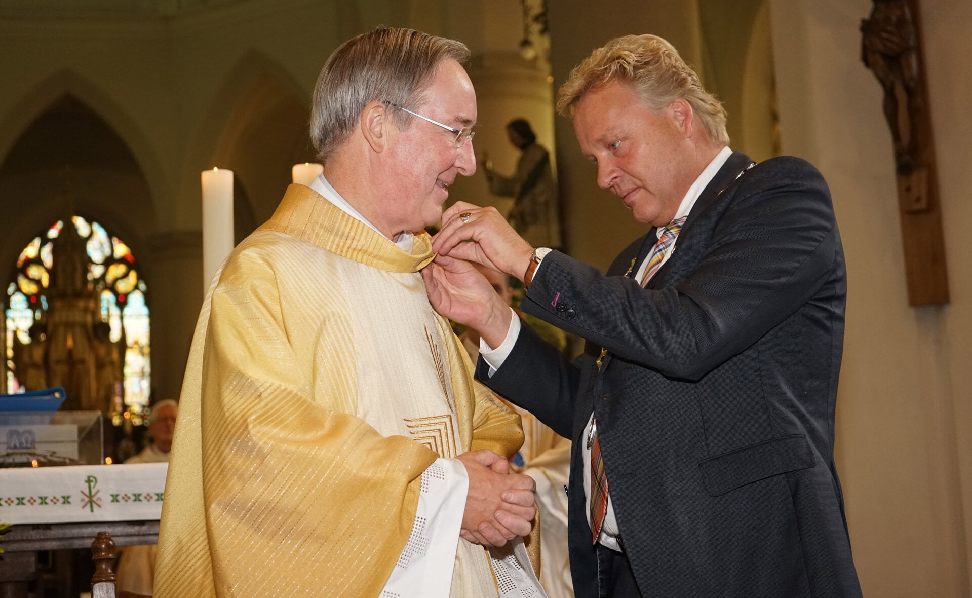 Burgemeester Mark Buijs reikt de gemeentelijke erepenning uit aan pastor Richard Niessen, die met emeritaat gaat. (Foto: Albert Stolwijk).