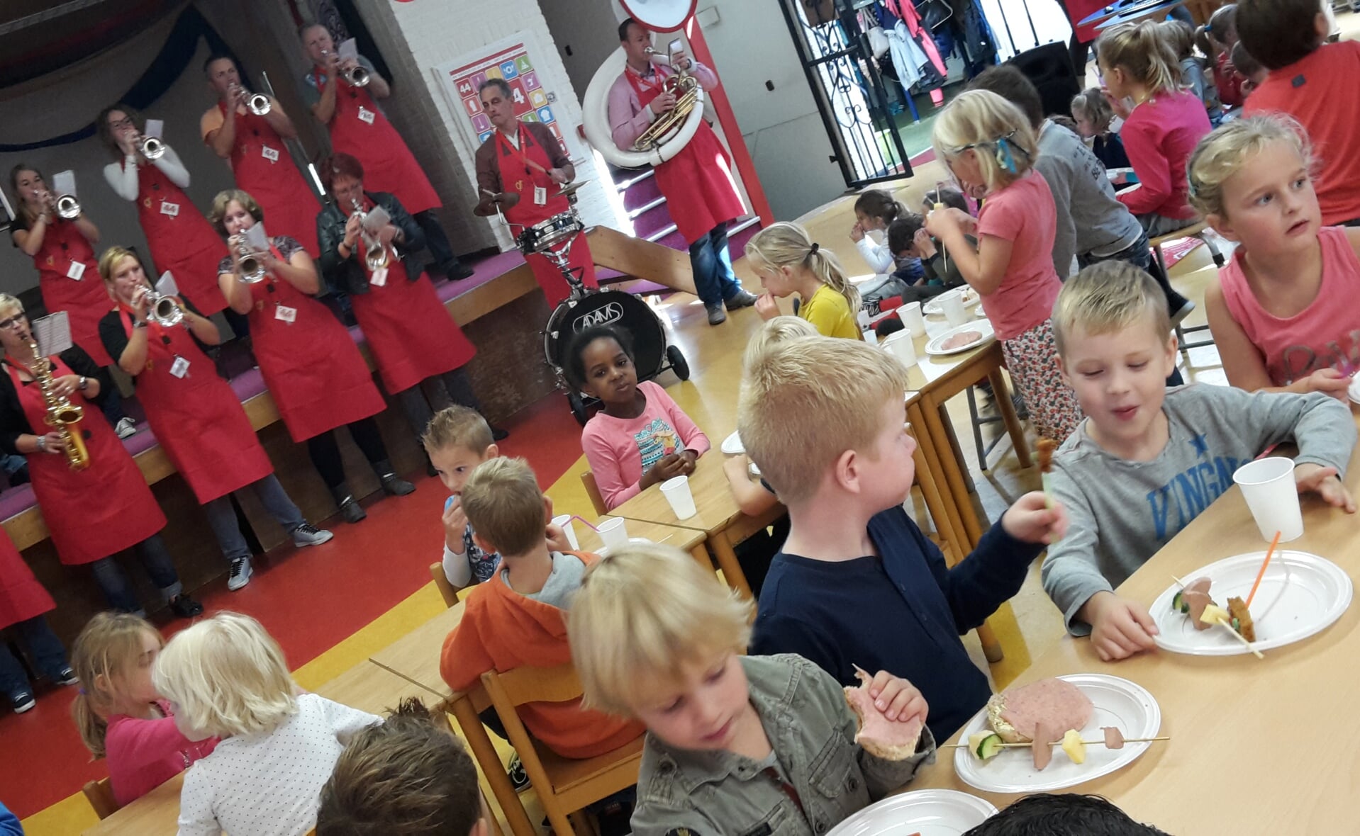 Op muziek van de jubilerende blaaskapel De Knoestjes smullen de leerlingen van de Sint-Willibrordusschool in Esch van zelfgemaakte hapjes. (Foto: Henk van Weert). 