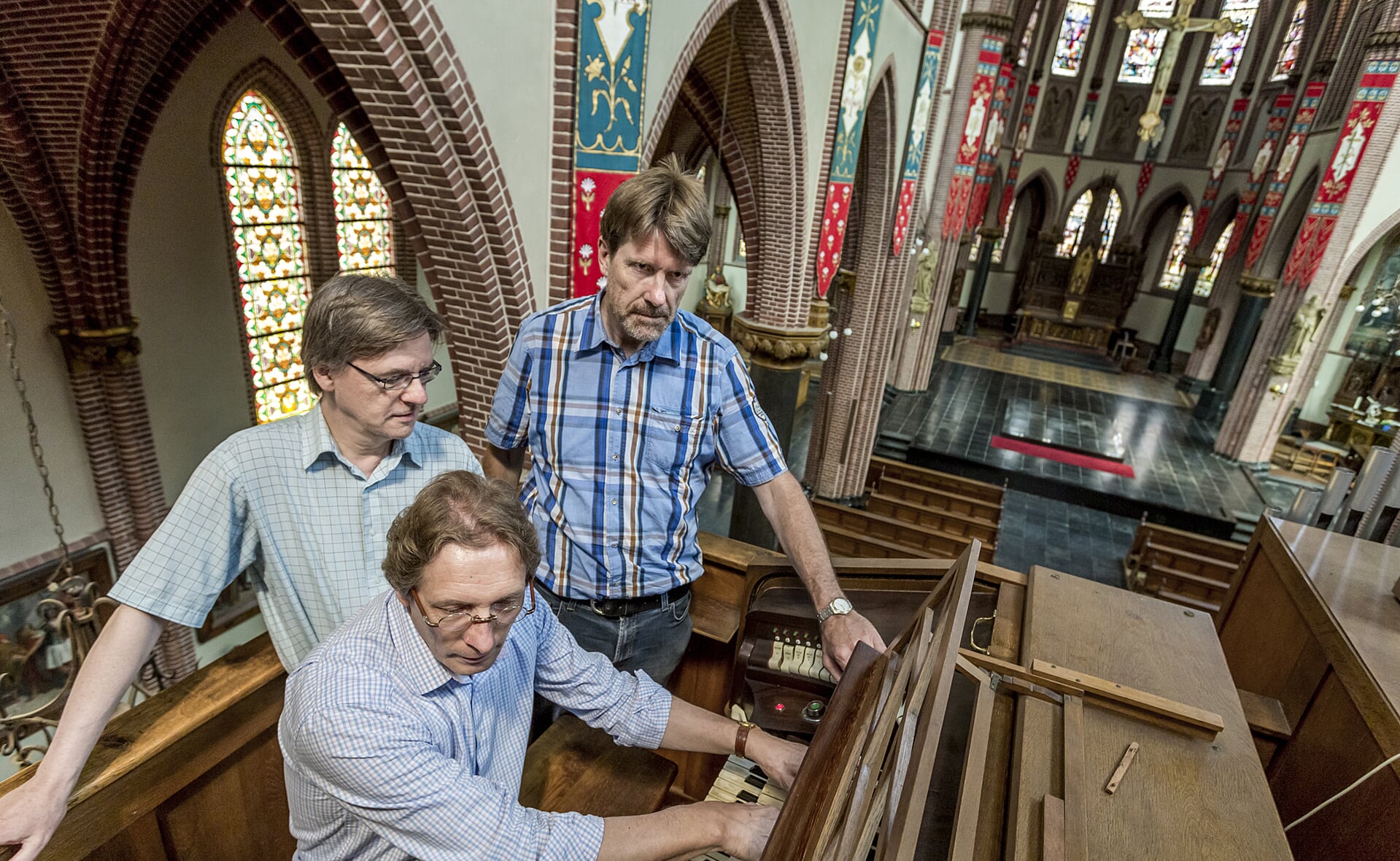 Maarten Koelink bespeelt het orgel in de voormalige Heilig Hartkerk, links Eric Schoones en rechts Dik Bol. Het drietal houdt tijdens open monumentendag een open podium in de leegstaande kerk. (Foto: Peter de Koning).