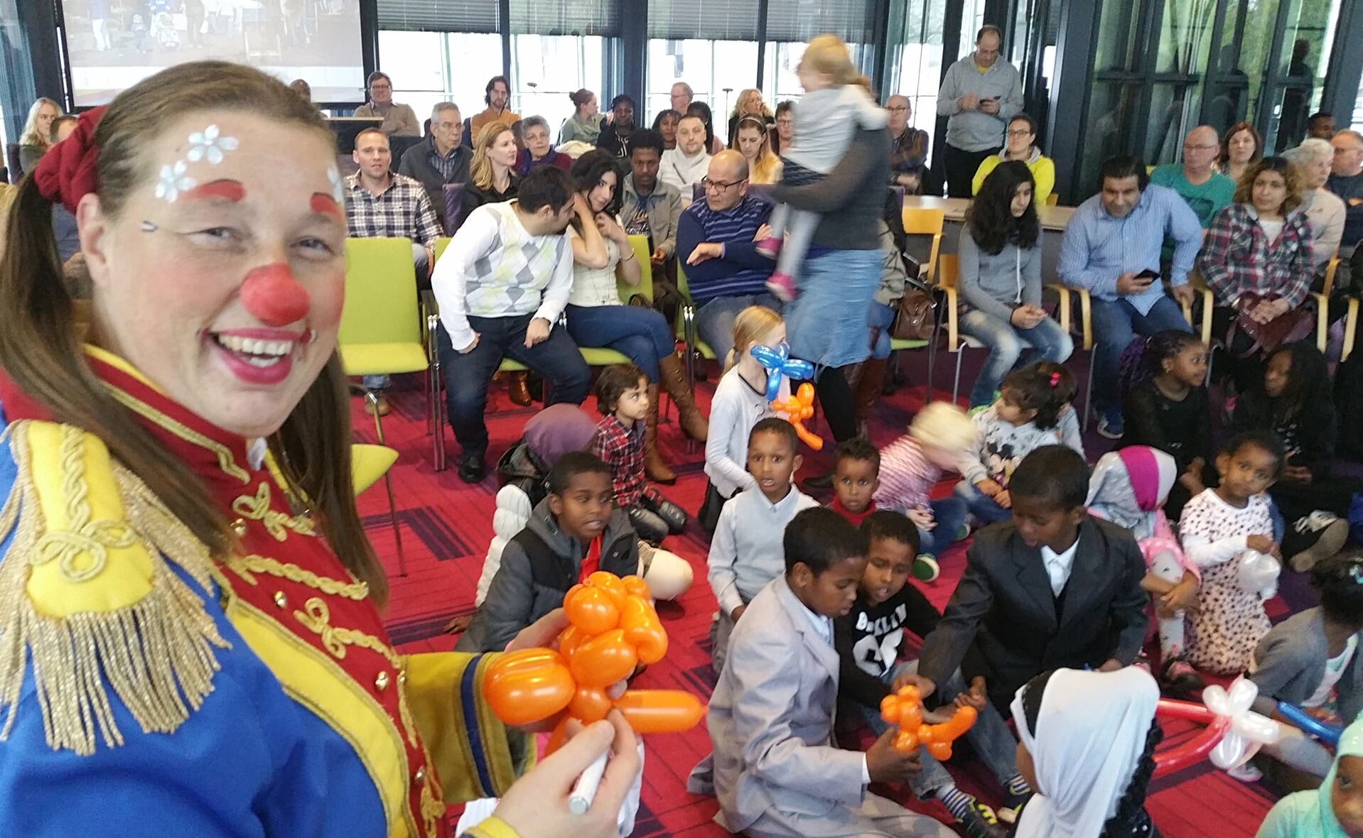 Clown Anka verrast alle kinderen van de nieuwkomers in Boxtel met kleurrijke ballonfiguren. (Foto: Marc Cleutjens).