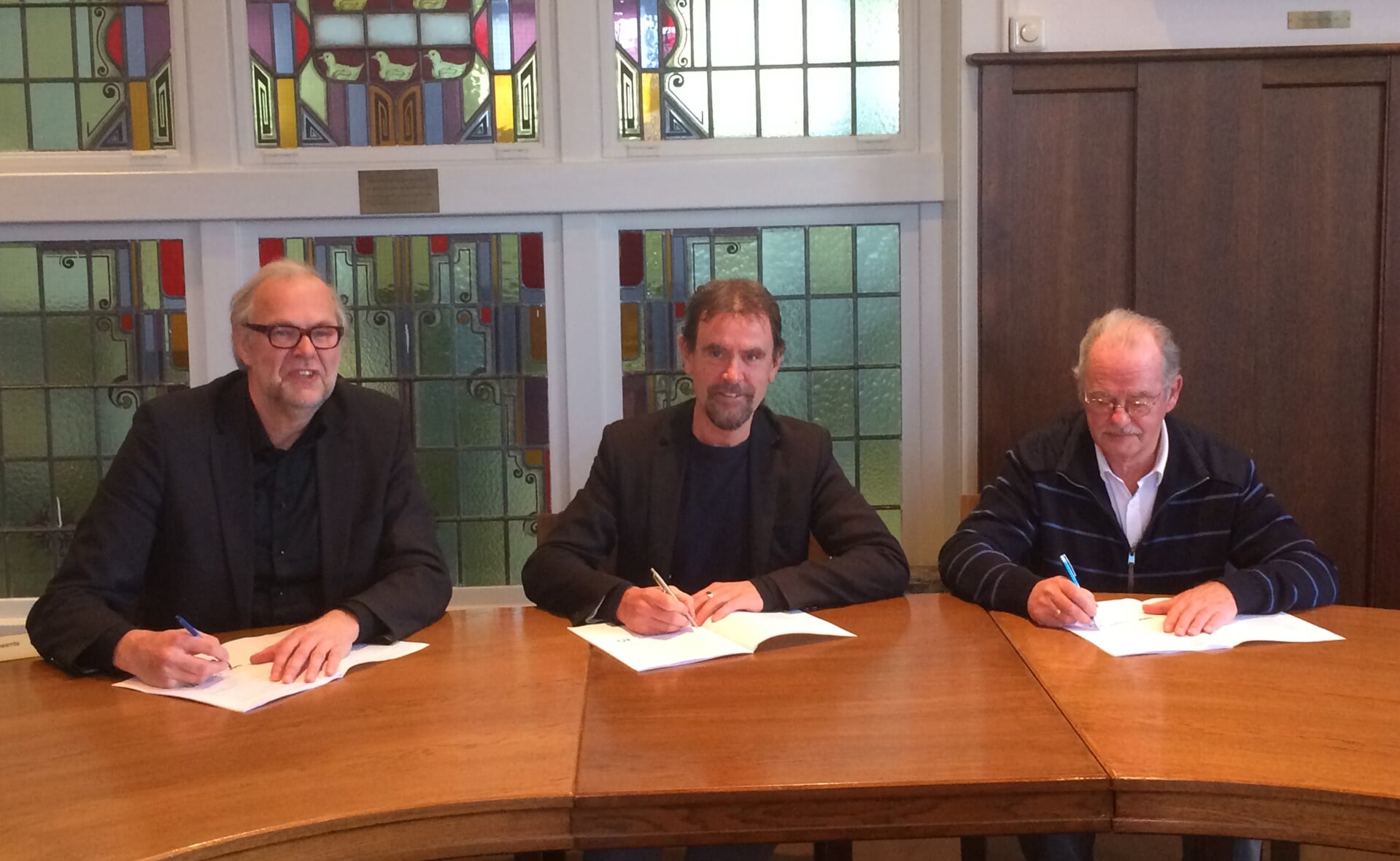 Rob Dekker (Sint-Joseph, links) en Ad Boleij (Huurdersbelangenvereniging, rechts) ondertekenen het prestatiecontract met wethouder Peter van de Wiel van Volkshuisvesting. (Foto: gemeente Boxtel).  