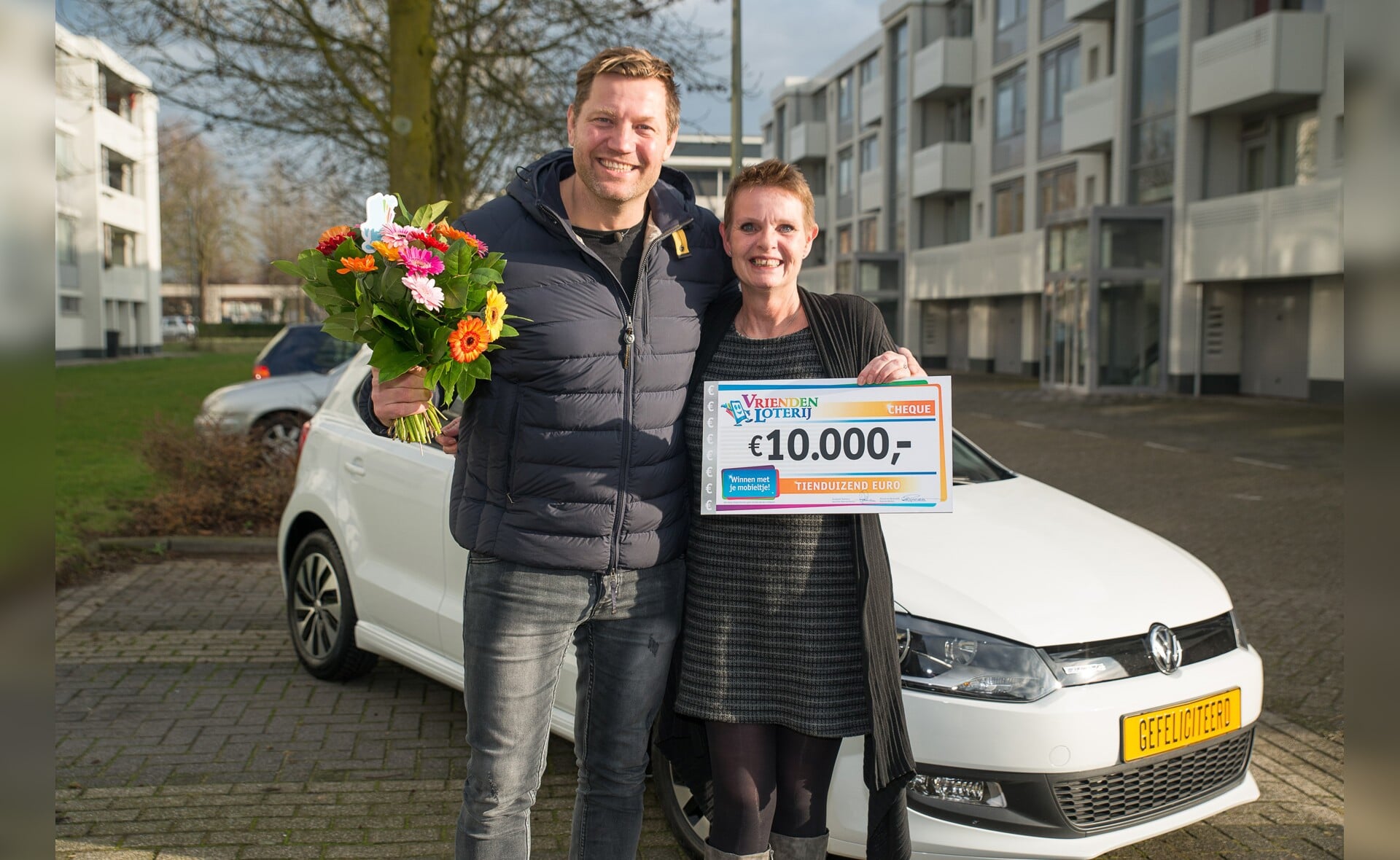 Marie-Louise uit Boxtel wint een Volkswagen Polo en 10.000 euro bij de VriendenLoterij. Zij ontvangt de prijs uit handen van VriendenLoterij-ambassadeur Dennis van der Geest.