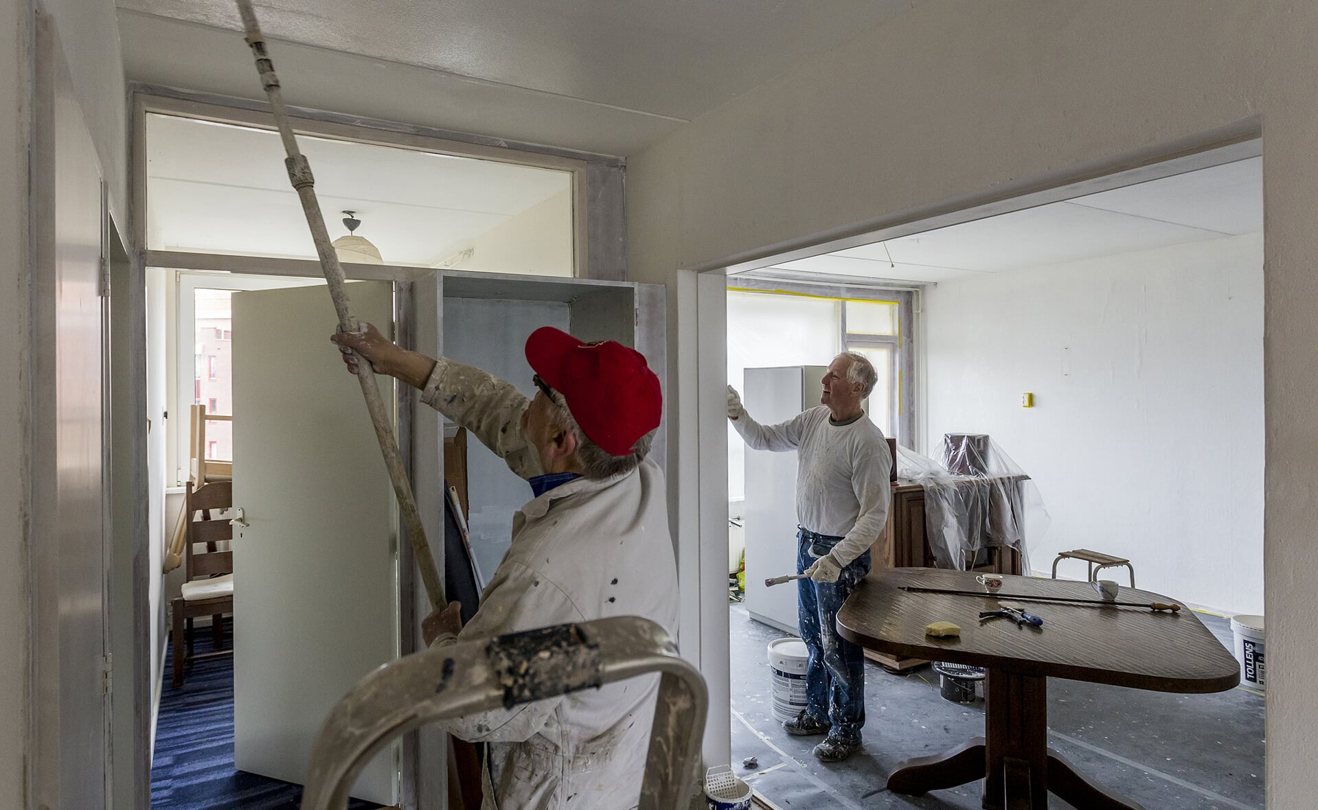Janus Melis (links) en Frans Schelle werkten deze week aan de inrichting van de Hoogheemflat die wordt omgevormd tot huiskamer voor 55-plussers in de zeven Boxtelse flats. (Foto: Peter de Koning).
