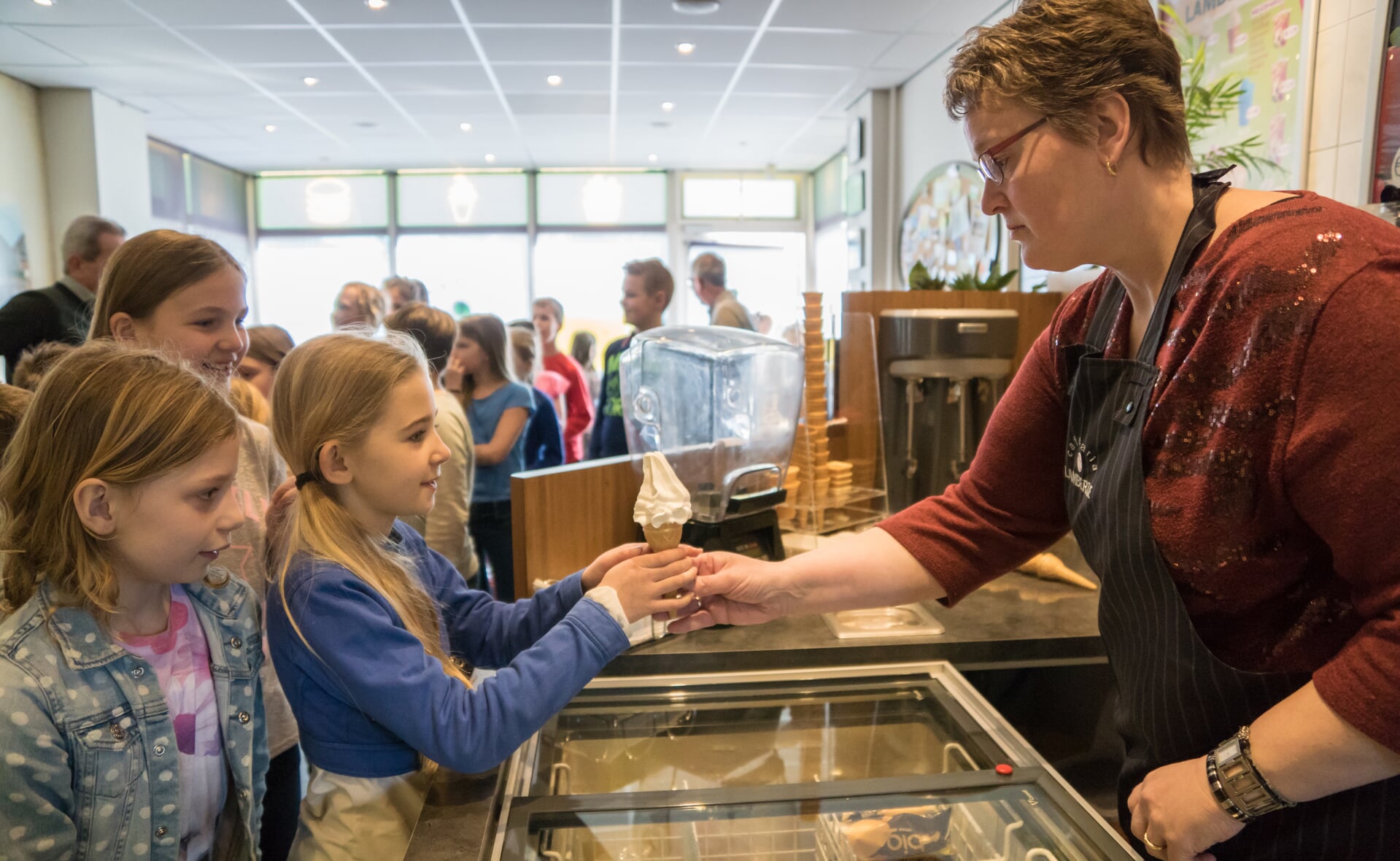 Ingrid van de Laar van cafetaria 't Lambertje deelt ijsjes uit van meester Wim Verhoeven van de Sint-Lambertusschool in Gemonde. Het was een heerlijke 1-aprilgrap... (Foto: Daisy Renders).