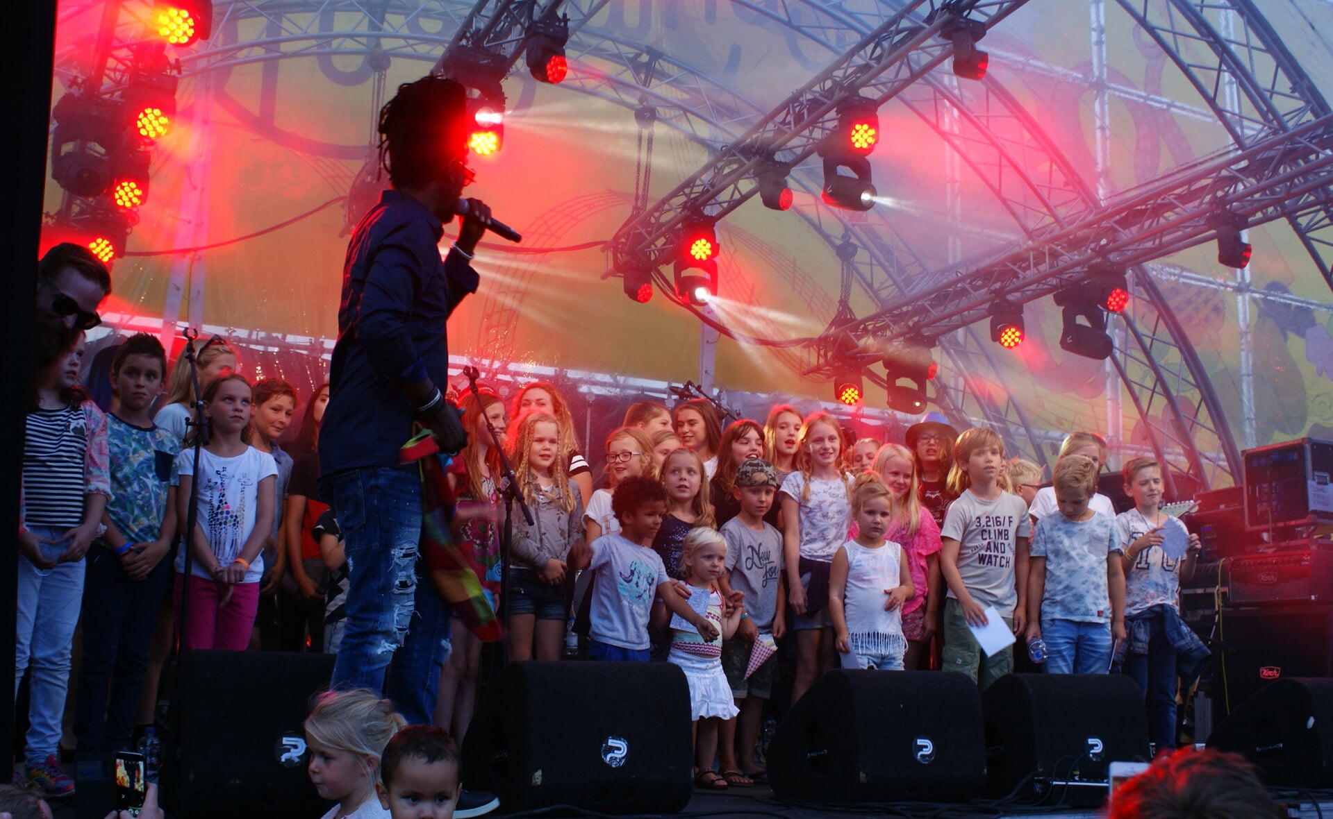 Kenny B zingt zijn hit 'Parijs' met alle jonge kinderen op Slowlands. Ze mochten zaterdagavond allemaal even 'on stage' komen om een groot Slowlands-koor te vormen. (Foto: Marc Cleutjens).