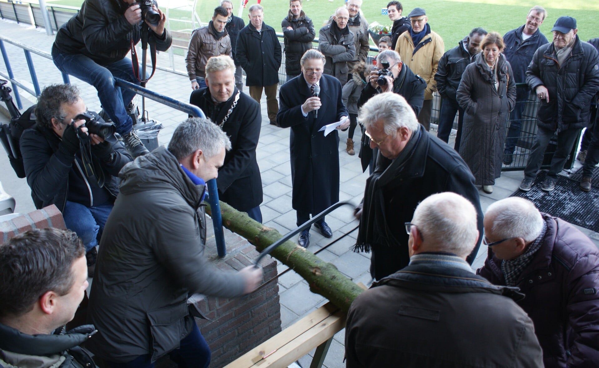 Henk (links) en Tonnie Wagenaars zagen een boomstam door en openen hiermee het vernieuwde ODC-sportpark Molenwijk. (Foto: Marc Cleutjens).
