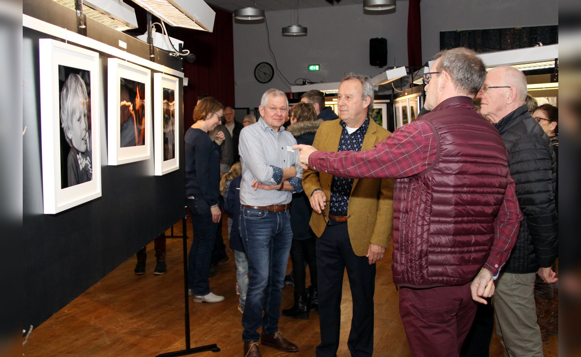 Wethouder Herman van Wanrooij (midden) bekijkt de eerste expositie van fotoclub Boxtel Ontspant. (Foto: Gerard Schalkx). 