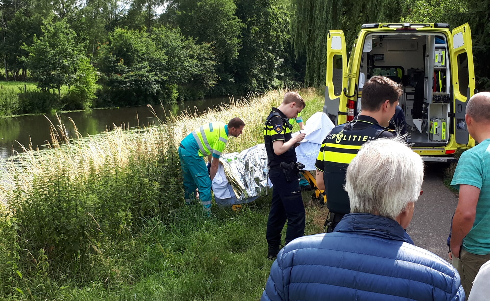 Ambulancebroeders en politiemensen ontfermden zich zondagmiddag over een vrouw, die met haar rolstoel te water was geraakt. Twee omstanders konden haar op tijd redden.