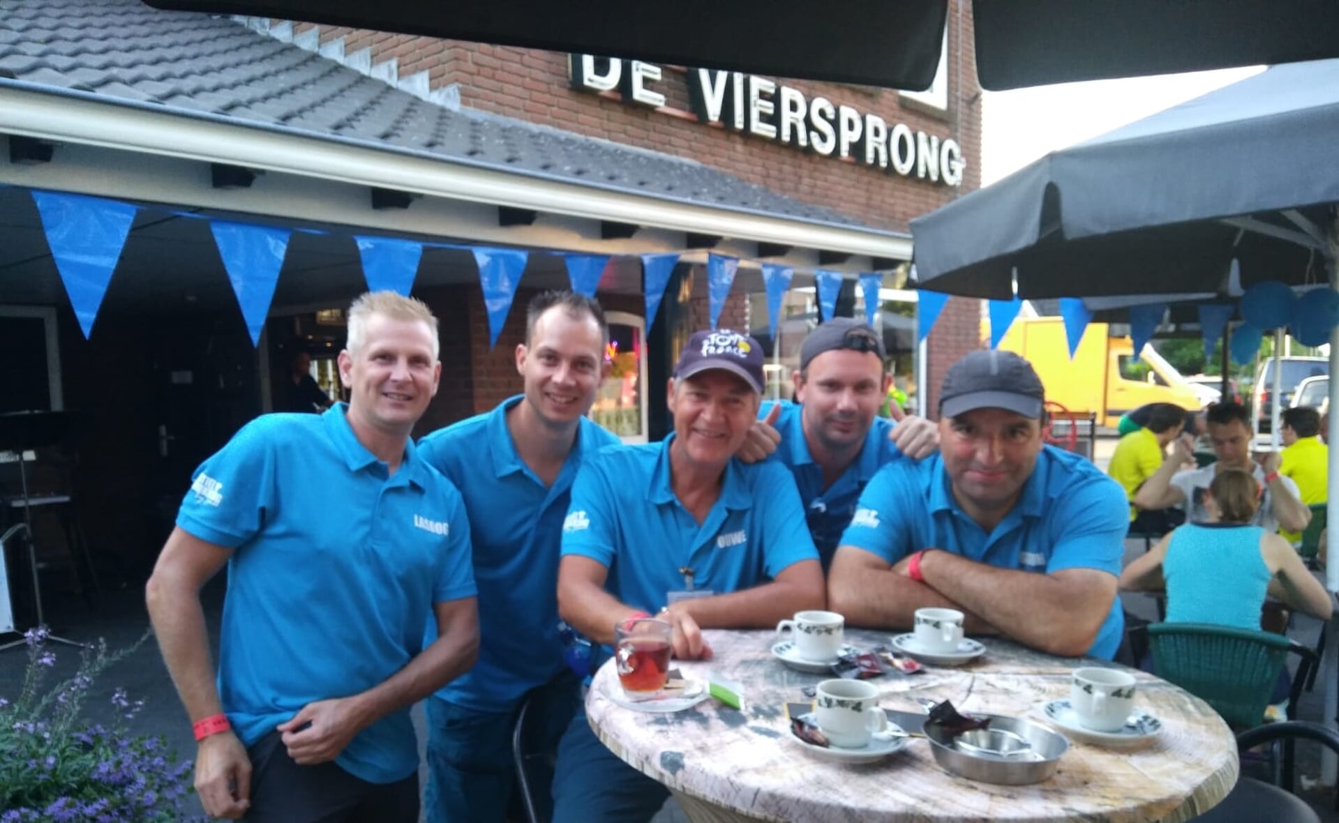 Rob van Weert, Olaf Voermans, Joop de Langen, Eric Pennings en Ariën Egge (v.l.n.r.) op een terras in Valburg, tijdens hun eerste pauze in de Nijmeegse Vierdaagse. 