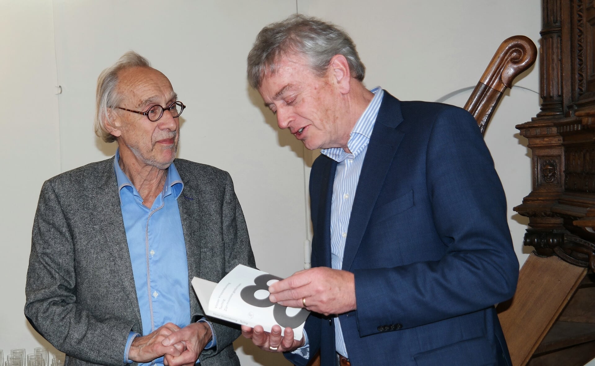 Ter gelegenheid van de tachtigste verjaardag van Victor Vroomkoning (links) werd in 2019 in het protestants kerkje van Boxtel een bundel gepresenteerd waarin vrienden de 120 mooiste gedichten samenbrachten. Waarnemend burgemeester Fons Naterop nam het eerste exemplaar van het boek destijds in ontvangst. 