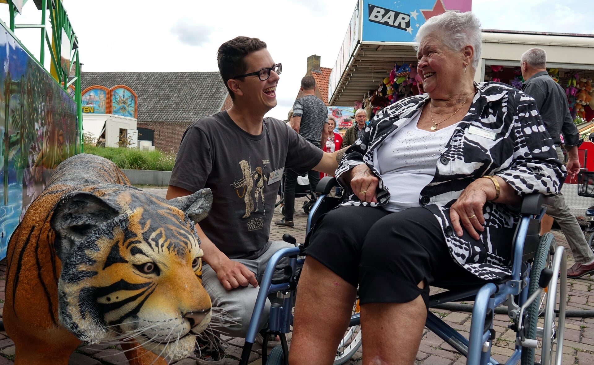 Journalist Rens van den Elsen in gesprek met Bertha Slits, die al 56 jaar in het centrum van Liempde woont. Ze hoeft niet zo nodig in een attracties, want ze 'zit al de hele dag in het kermisgedruis'. (Foto's: Albert Stolwijk). 