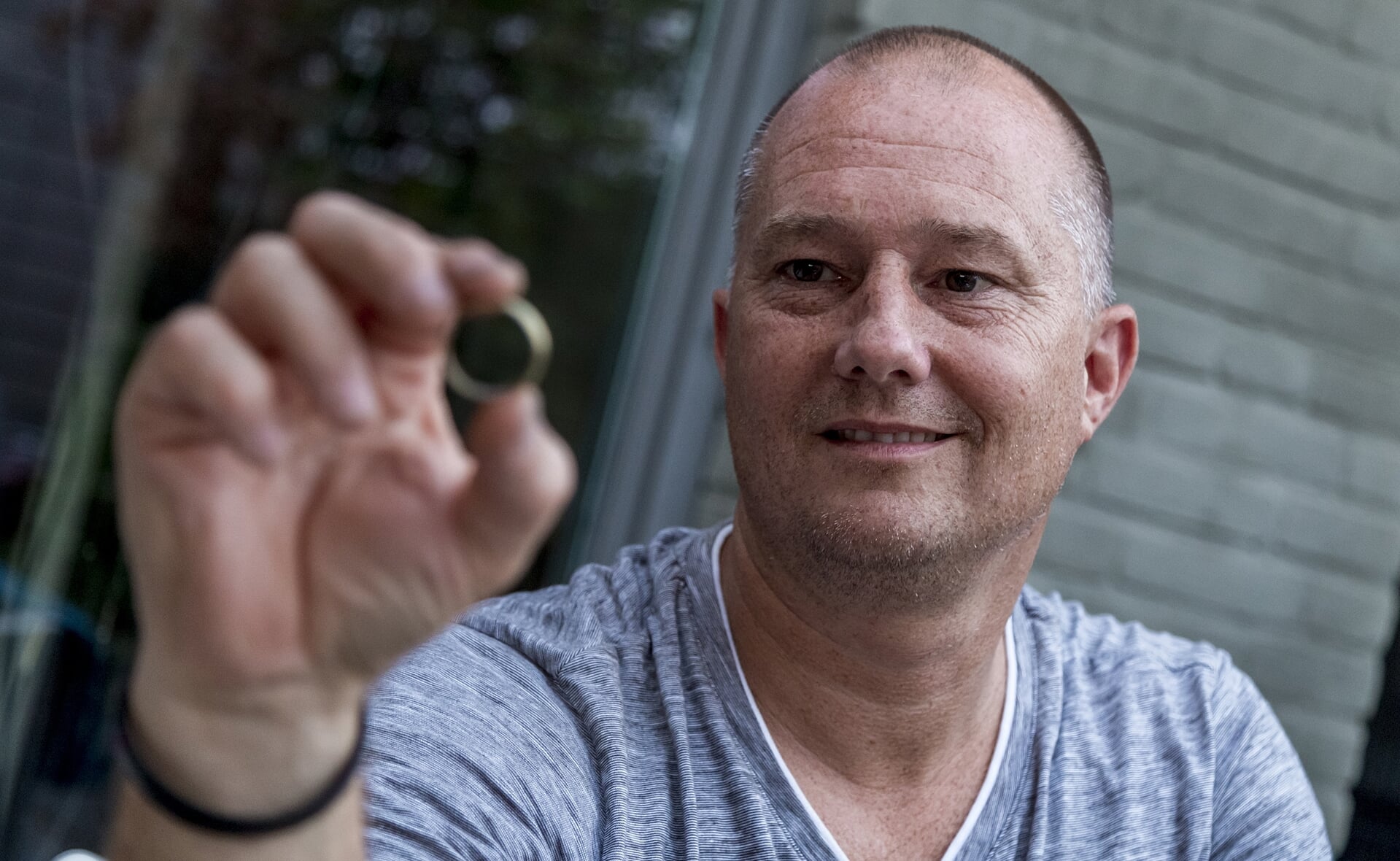 Schatzoeker Erik van Asveldt toont de gouden trouwring. Hij vond deze middels zijn metaaldetector in een weiland. Naast de ring heeft de Boxtelaar nog veel meer 'schatten' uit het verleden gevonden. (Foto: Peter de Koning).