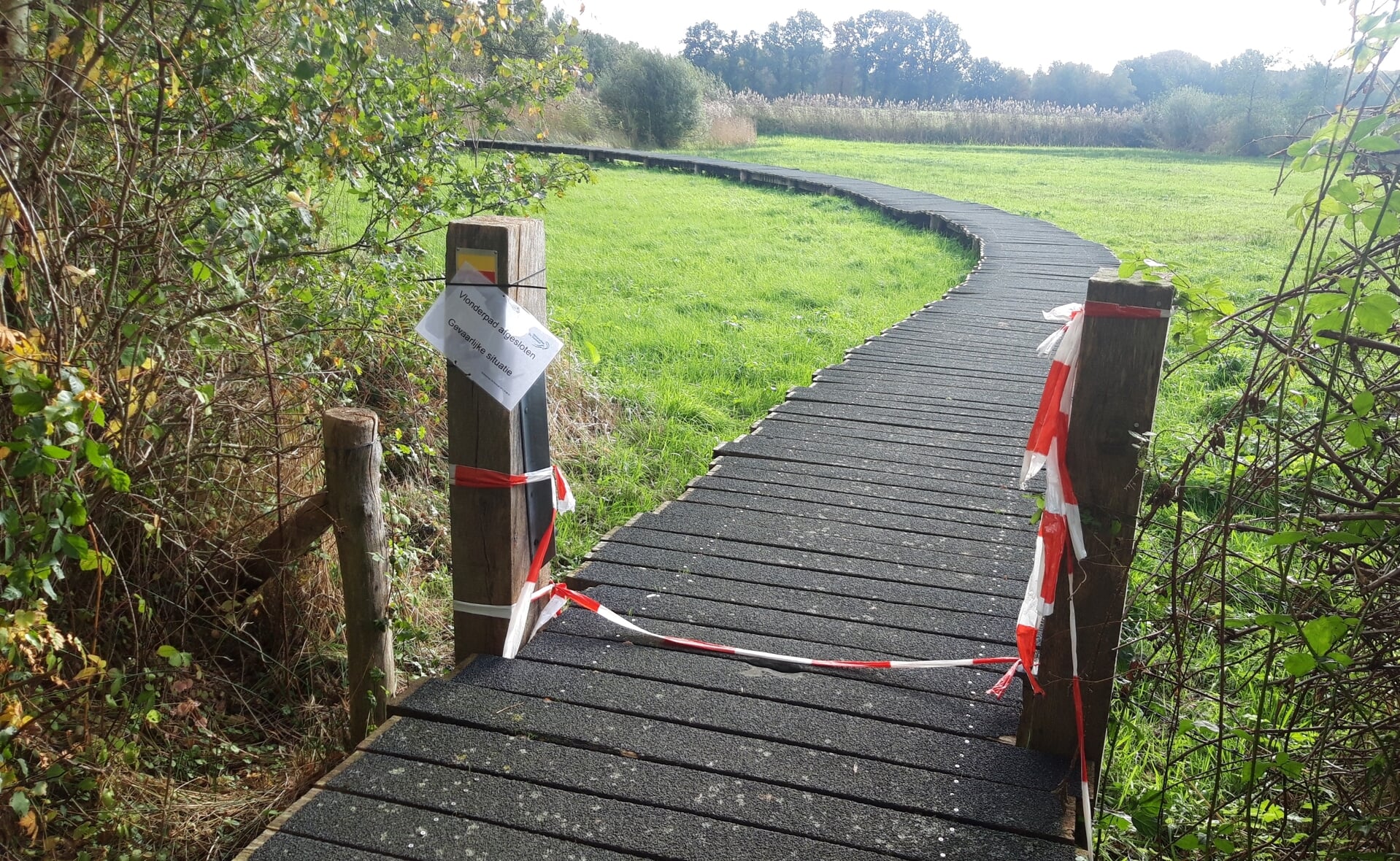 Het in 2012 geopende vlonderpad in Boxtel-Oost is afgesloten met rood/wit lint, maar daar laten wandelaars zich niet door tegenhouden.