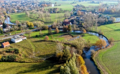 Blik in oostelijke richting op de meanderende Dommel. Het witte gebouw links is het voormalige Joris Meubelen, Het groene gebied rechts daarvan is aangekocht door stichting Dommelbimd. (Foto: Albert Stolwijk).