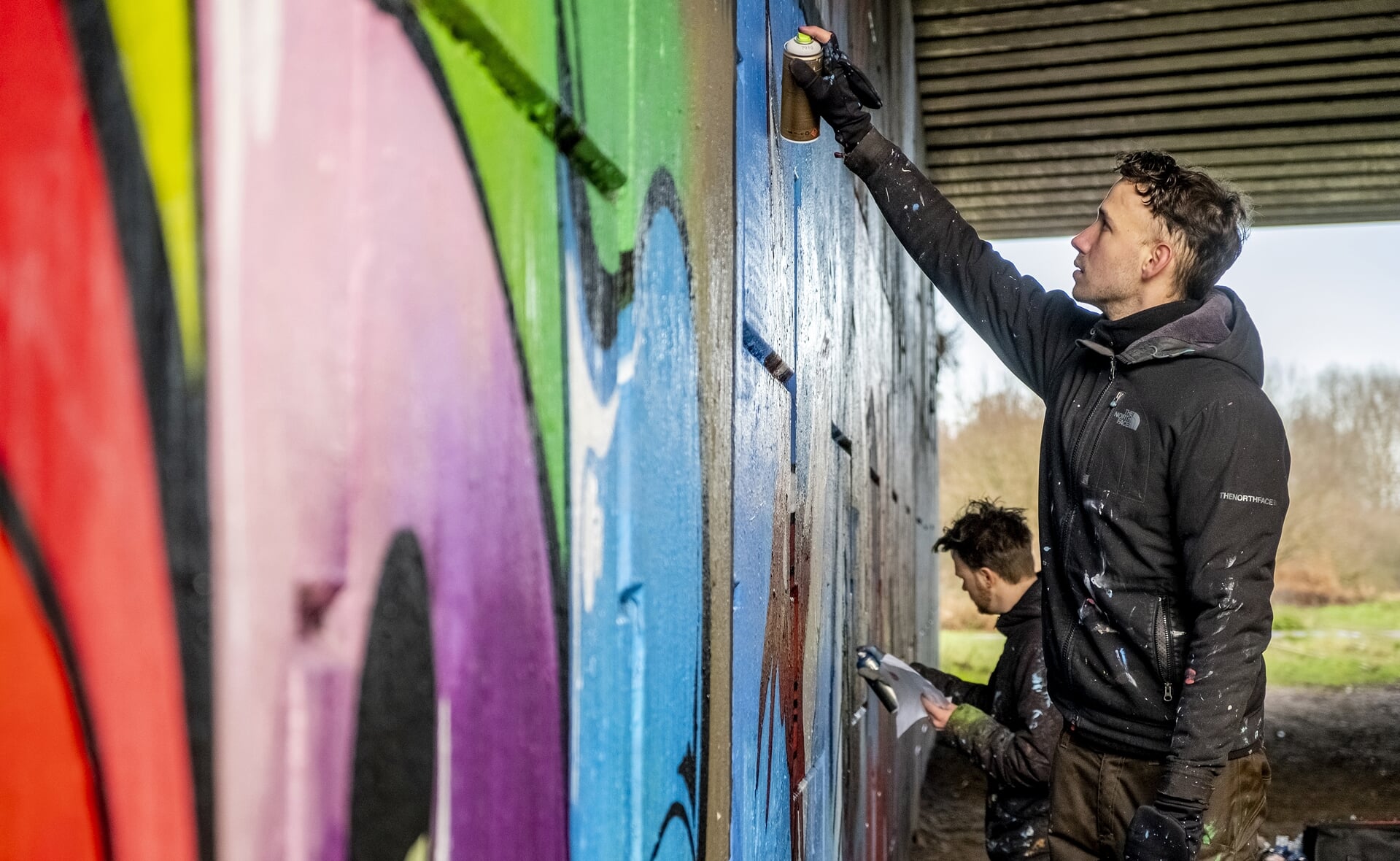Jan Pennings (op de voorgrond) en Paul Jongsma van stichting Tunnel Vision Boxtel maakten in opdracht van het team van ‘Boxtel – 2020 in 366 verhalen’ een graffitikunstwerk. Het fraaie resultaat is te zien in de verhalenbundel die begin 2021 verschijnt. (Foto: Peter de Koning).