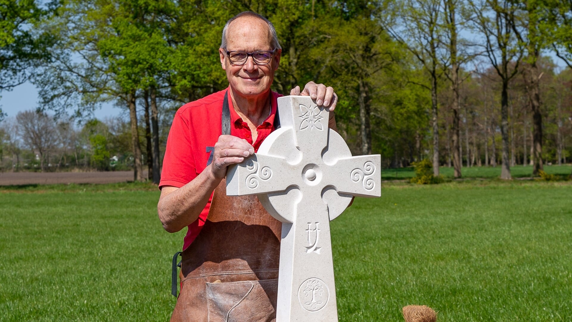 Beeldhouwer Marten Groen met het Keltisch kruis dat hij maakte.