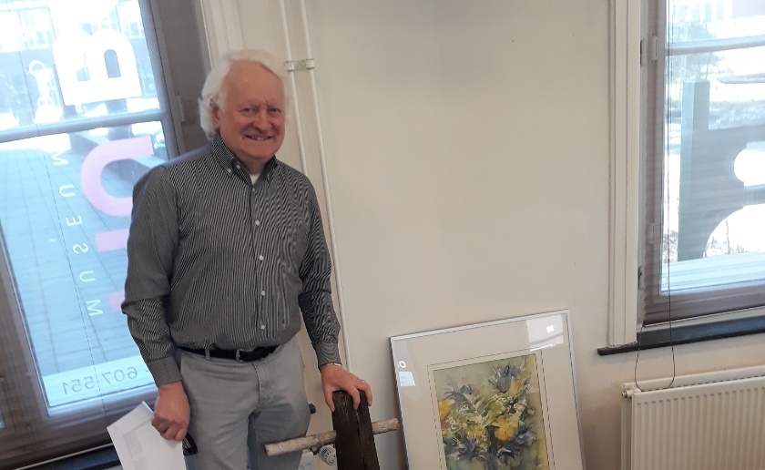 Jerôme van Helvoort bij twee van de geschonken objecten in MUBO: de originele keistamper en de aquarel van kunstschilder Frans Bank. Foto: MUBO