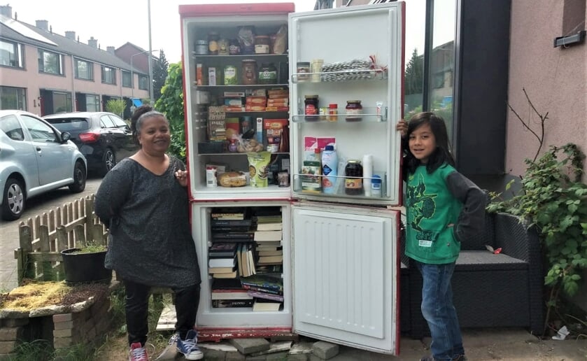 Minou-Varsha en haar zoon Eshwar bij hun tot mini-bieb en kringloop omgedoopte koel/vriescombinatie