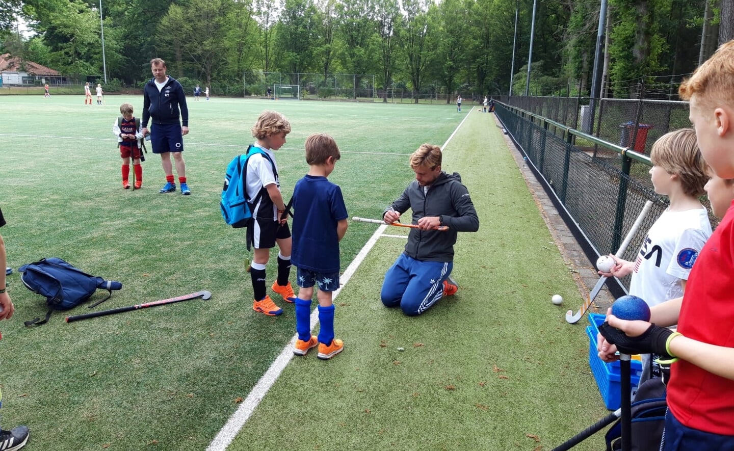 Mink van der Weerden signeert hockeysticks van de MEP-jeugd. 