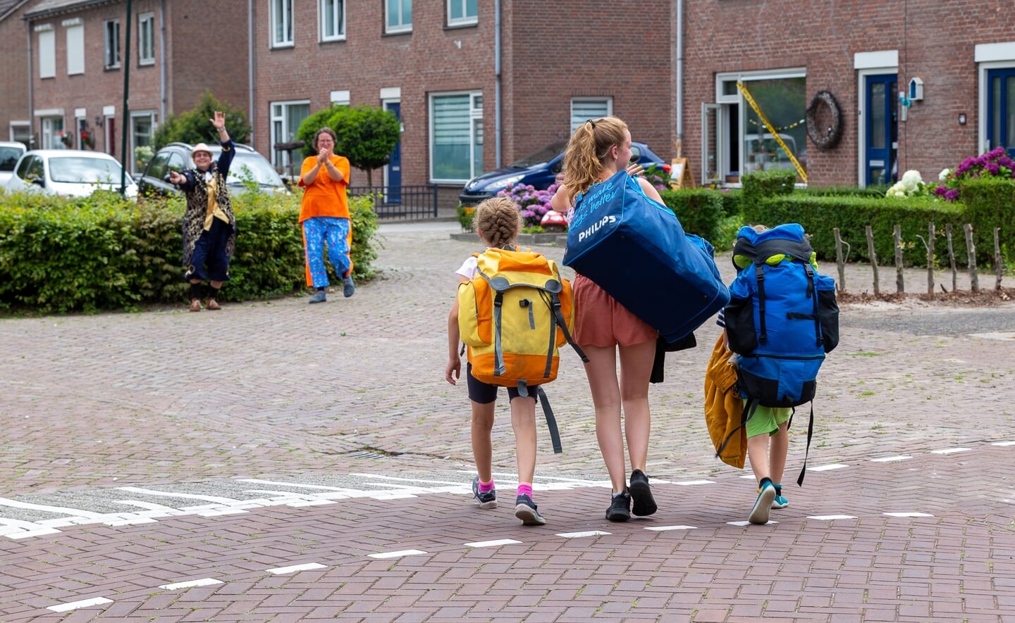 Ouders Willem en Tessa wachten hun drie kinderen op, die met bepakking naar de Oude Dijk komen gewandeld voor hun zomerkamp.