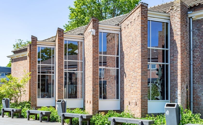 Tijdens de lezing in MuBo geeft architect Harrie van Helmond een fotorondleiding door het Jacob-Roelandslyceum. (Foto: Rini van Oirschot).