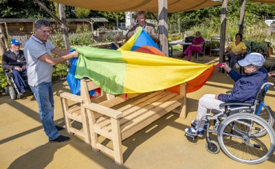 Martien Roestenburg (links) en Frans van Boeckel (midden) onthulden woensdag de banken die zij schonken aan de Dommeltuin bij zorgexpertisehuis Liduina.