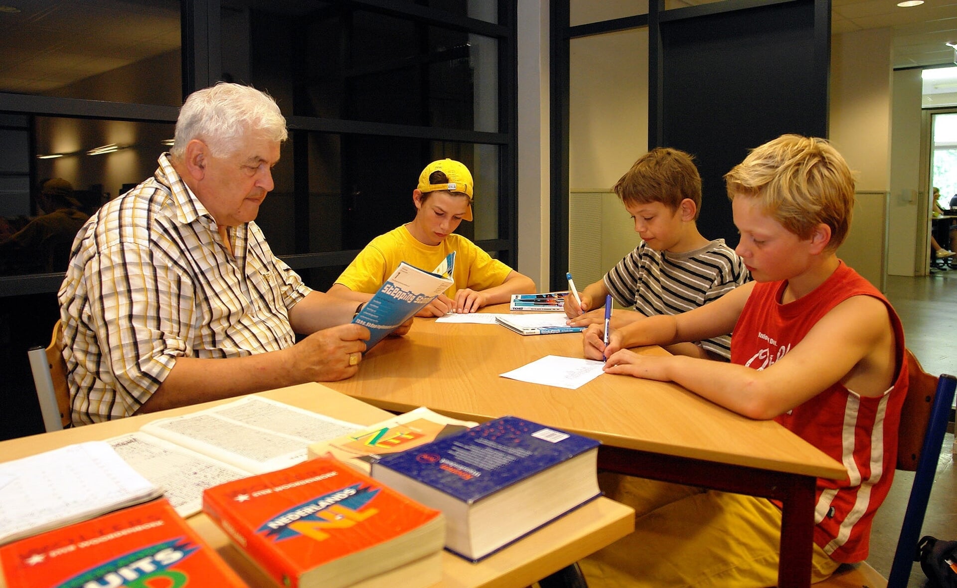 Leo van Dongen begeleidt leerlingen van het Jacob-Roelandslyceum in de huiswerkklas. De Boxtelse docent bleef dat doen tot zijn tachtigste verjaardag. (Foto: Albert Stolwijk, 2006).
