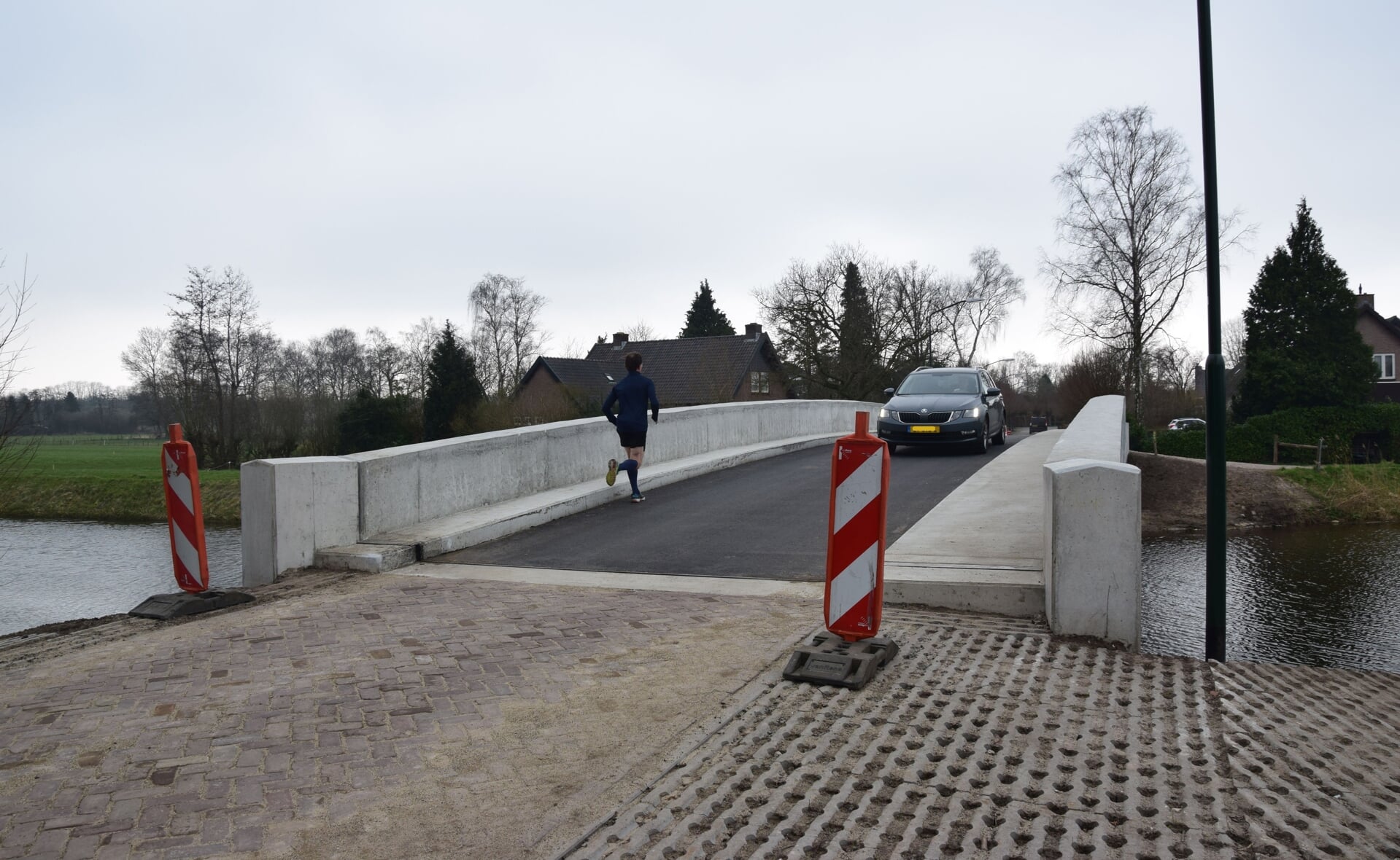 Met ruim drie maanden vertraging werd vrijdag zonder al te veel vertoon de brug over de Essche Stroom tussen de Spankerstraat en Groenendaal in Esch geopend voor het publiek. (Foto: Rens van den Elsen).