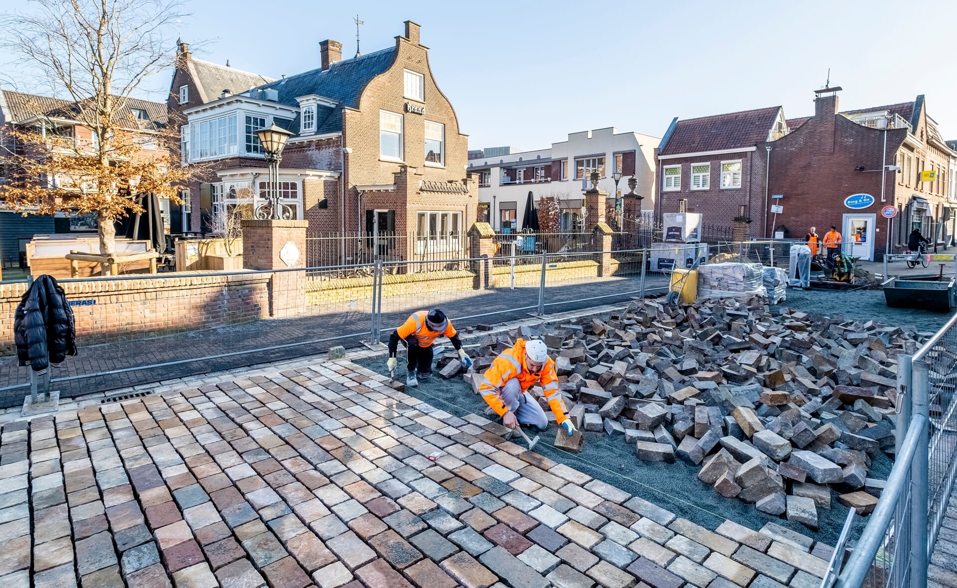 Stratenmakers van aannemingsbedrijf Heijmans aan het werk in de Rechterstraat. De Zwaanse Brug is al geplaveid met Italiaans natuursteen. (Foto: Peter de Koning).