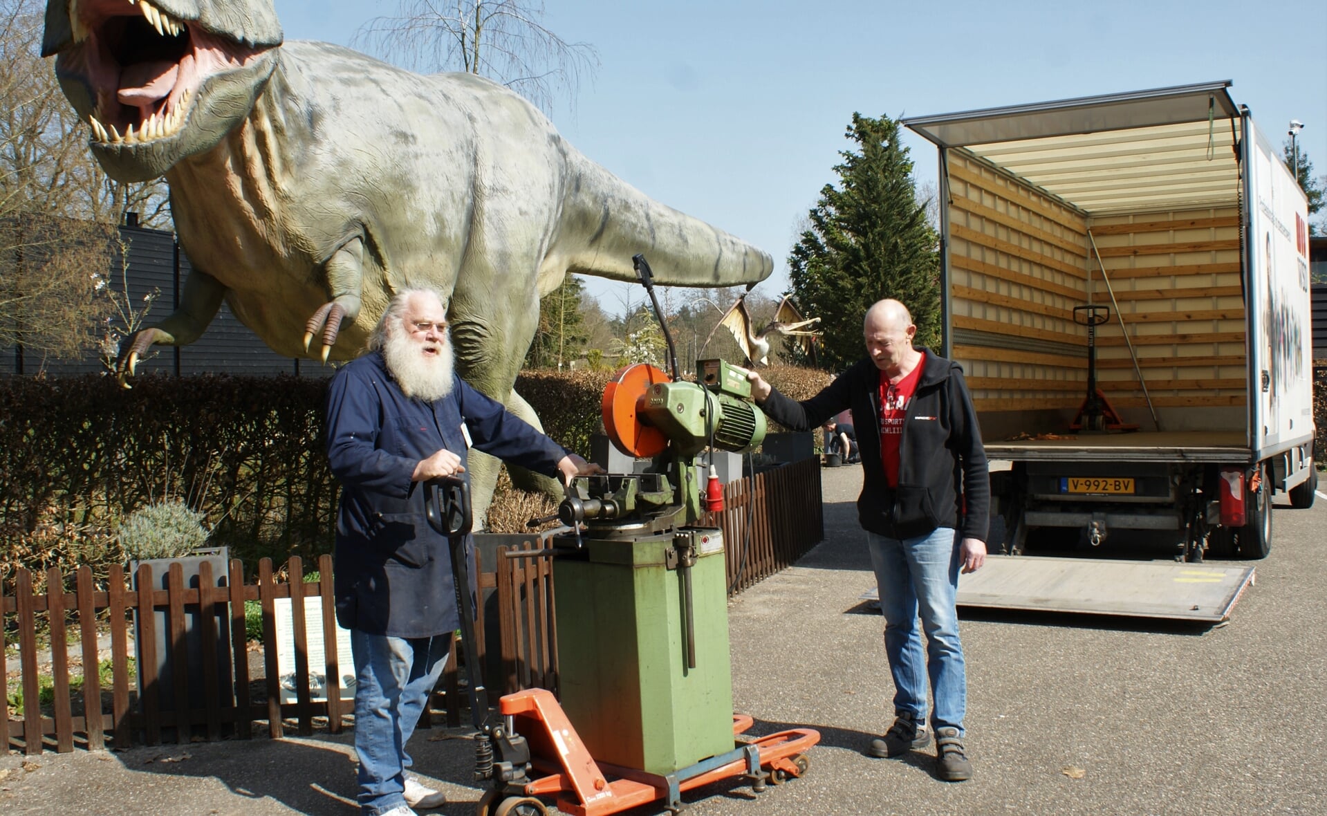 Museumvrijwilliger Ko Wijnstok (links) neemt de metaalzaag van WSD-technicus Jan de Laat in ontvangst. Het gereedschap draagt bij aan de reconstructie van een uniek Diplodocus-skelet. (Foto: Marc Cleutjens).