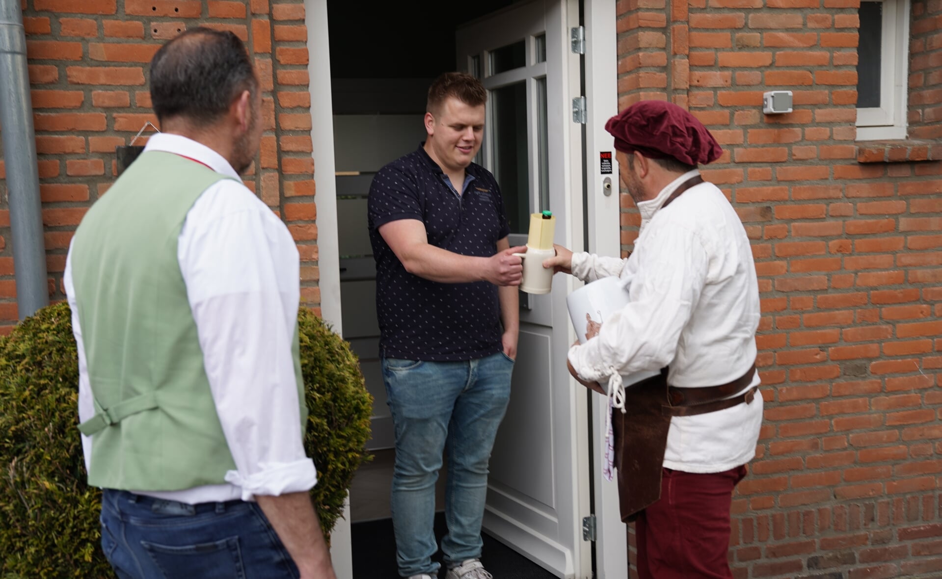 Frank de Man (links) van het Essche Bierpompcomité belde donderdag samen met biertapper Gerrie van der Mee (rechts) aan bij de nieuwe inwoners van Esch. 
