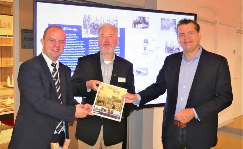 <p>Filiaalmanager Oskar Martens van Jumbo Oosterhof (links) en Henk van Beers van Heemkunde Boxtel (midden) geven het eerste exemplaar aan wethouder Hans Heesen van de gemeente Boxtel. (Foto: Ad van de Wetering).</p>