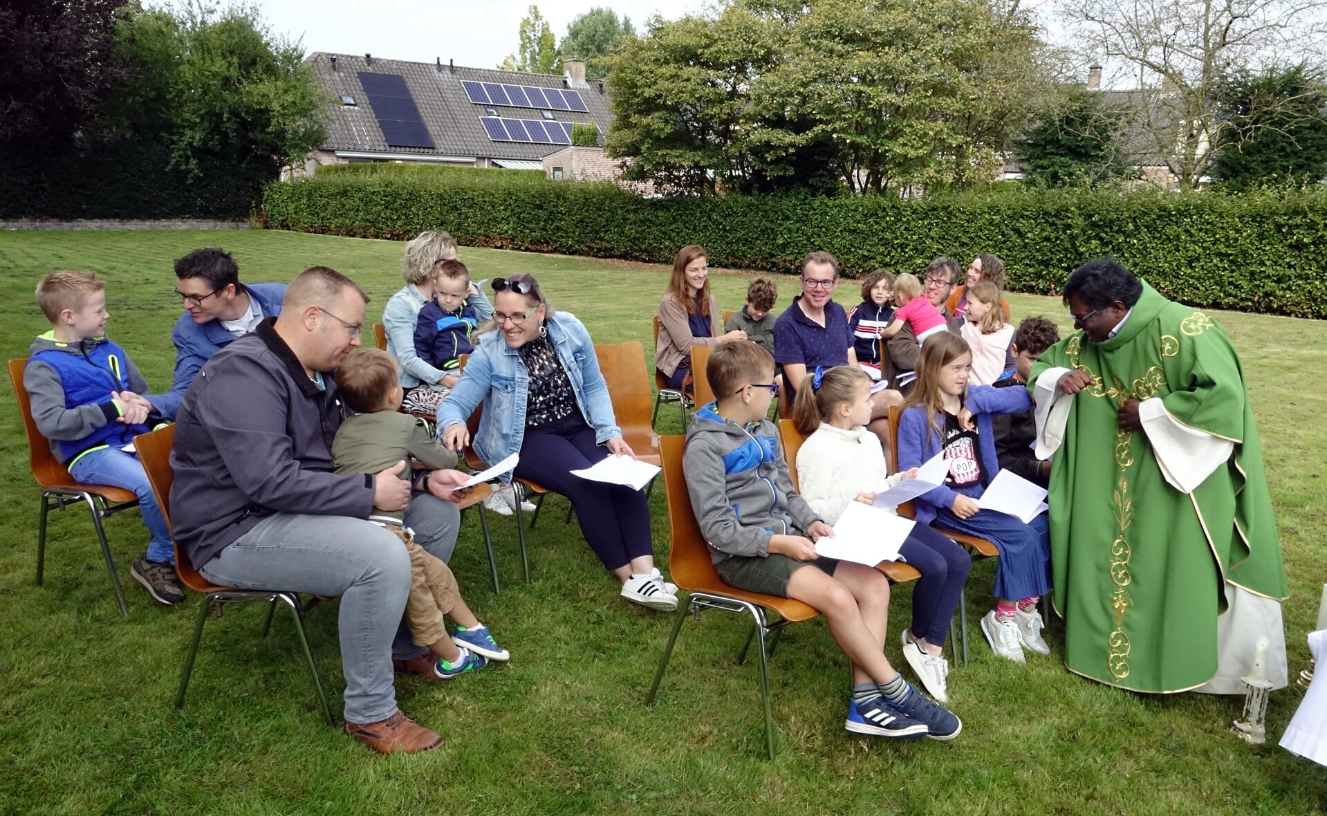 Kapelaan Stanislaus tijdens een openluchtviering in Liempde met kinderen die de eerste communie hadden gedaan. 