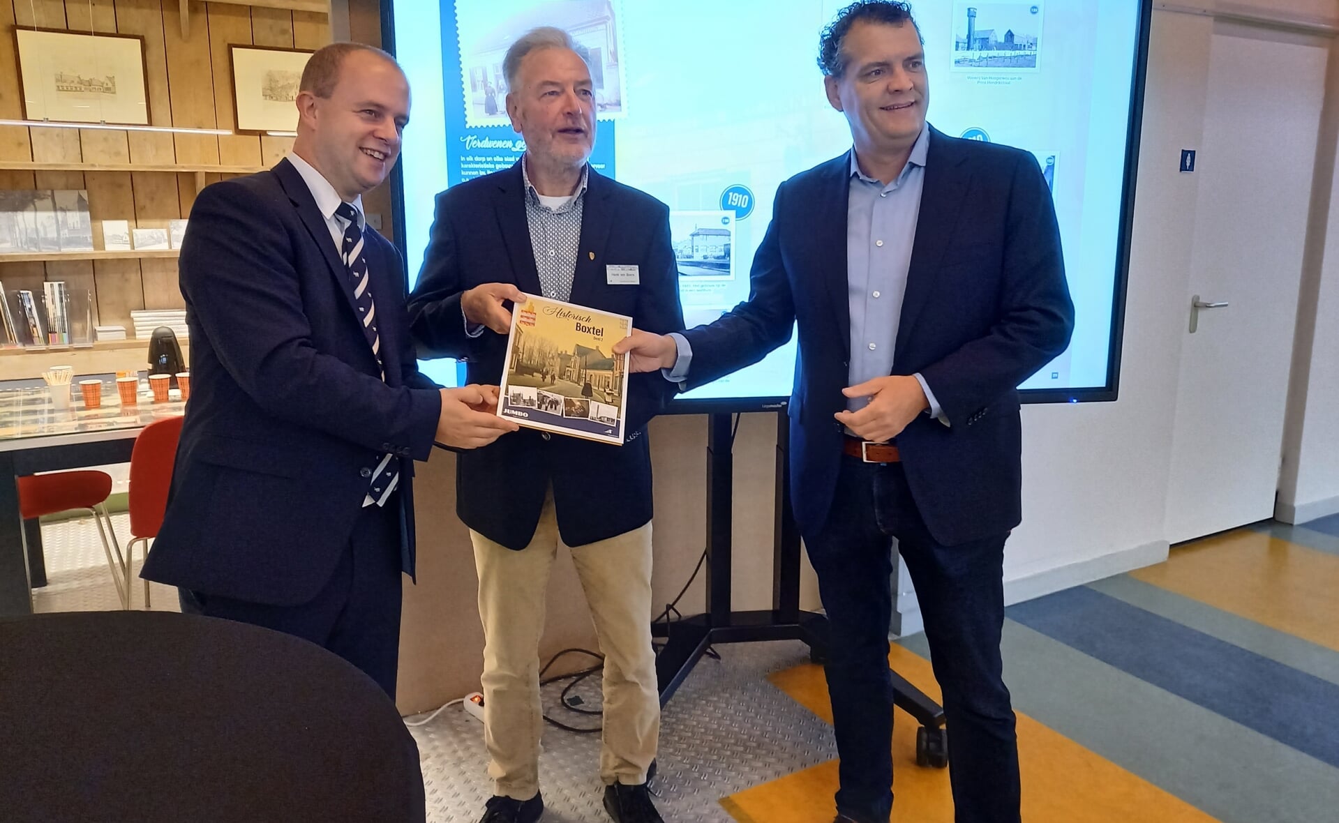 Oskar Martens (links) en Henk van Beers (midden) overhandigen wethouder Hans Heesen het eerste boek. (Foto: Jan Hermens).